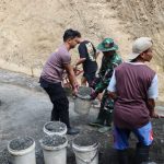 Personel TNI dan Polri bahu-membahu bersama warga melangsir batu split untuk mendukung pembangunan rabat beton di Dusun Kunir RT 01/RW 09, Desa Gumelem Kulon, Kecamatan Susukan, Minggu (2/8/2026).
