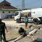 Bergandengan tangan dengan Babinsa Desa Kesongo, Serka Lasmidi, para personel Satgas TMMD menerjang terik musim kemarau untuk mendistribusikan air bersih langsung ke rumah-rumah warga di Dusun Krebet RT.013 RW.006, Desa Kesongo, Kecamatan Kedungadem, Kabupaten Bojonegoro, Selasa (4/8/2026).