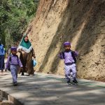 Noval, anak PAUD Desa Gumelem Kulon, melintas di lokasi pembangunan rabat beton TMMD Reguler ke-129 Kodim 0704/Banjarnegara sambil menyapa anggota Satgas yang sedang bekerja di Dusun Kunir RT 01/09, Kecamatan Susukan, Kamis (6/8/2026). Pembangunan jalan TMMD menjadi harapan baru bagi generasi muda desa. Foto: Deni Aripandi/Sumber TMMD Banjarnegara