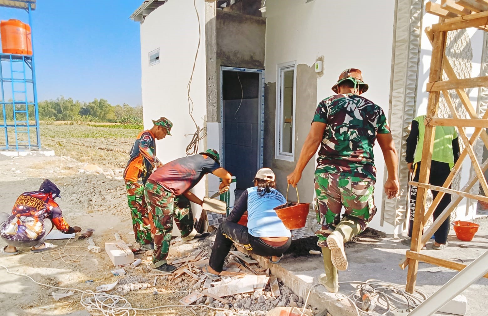 Teliti hingga Detail: Serma Juni, Wakil Komandan Regu 1 SST-3 SSK Satgas TMMD ke-129 Kodim 0813 Bojonegoro, memotong keramik untuk lantai mushola di rest area Desa Kesongo, Kecamatan Kedungadem, Kabupaten Bojonegoro, Kamis (6/8/2026). Ketelitian dalam setiap tahap pekerjaan dilakukan untuk memastikan hasil pembangunan rapi dan berkualitas.