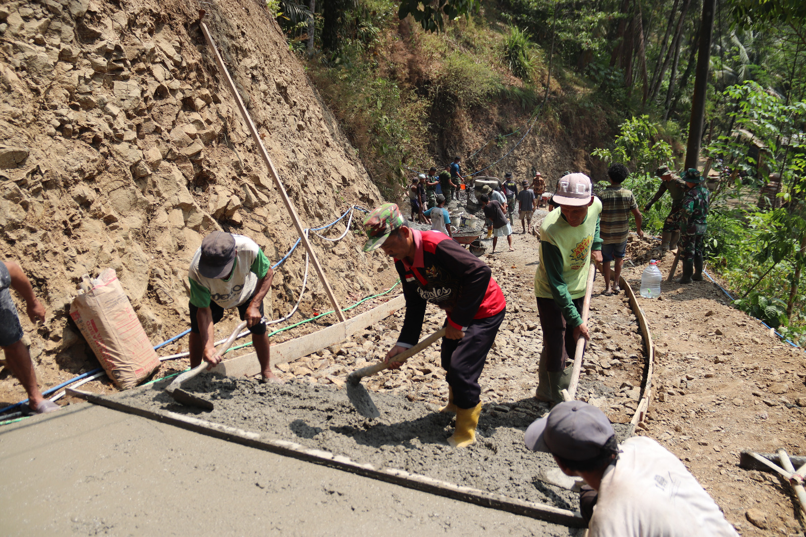 Tokoh Warga Dampingi TMMD: Ketua RW 09 Pak Sakum memantau dan mendampingi proses pembangunan rabat beton bersama anggota Satgas TMMD Reguler ke-129 Kodim 0704/Banjarnegara di Dusun Kunir, Desa Gumelem Kulon, Kecamatan Susukan, Jumat (7/8/2026).