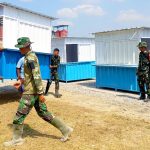 Personel Satgas TMMD ke-129 Kodim 0813/Bojonegoro bersama masyarakat saat memindahkan dan menempatkan enam unit booth container UMKM di Rest Area Terpadu Desa Kesongo, Kecamatan Kedungadem, Kabupaten Bojonegoro, Senin (10/8/2026). Foto: Deni Flamboyan/Sumber TMMD Bojonegoro Personel Satgas TMMD ke-129 Kodim 0813/Bojonegoro bersama masyarakat saat memindahkan dan menempatkan enam unit booth container UMKM di Rest Area Terpadu Desa Kesongo, Kecamatan Kedungadem, Kabupaten Bojonegoro, Senin (10/8/2026). Foto: Deni Flamboyan/Sumber TMMD Bojonegoro