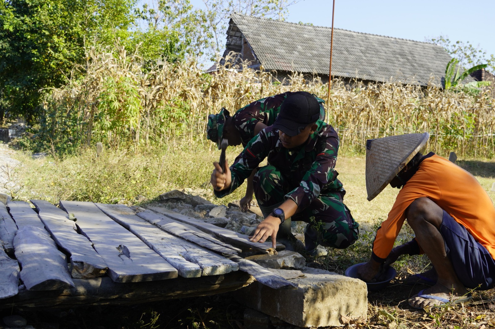Setelah menyelesaikan pekerjaan utama TMMD, sejumlah prajurit menyempatkan diri membantu warga memperbaiki jembatan dan membersihkan pekarangan rumah di Dusun Kedungpandan, Desa Kesongo, Kecamatan Kedungadem, Kabupaten Bojonegoro, Sabtu (1/8/2026).