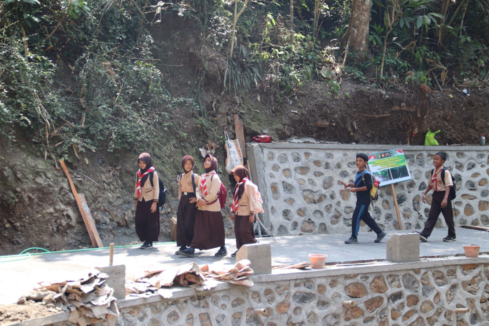 Hal tersebut terlihat saat Aliya, siswi SD Negeri 6 Gumelem Kulon, melintasi lokasi pembangunan rabat beton sepulang sekolah di Dusun Kunir RT 01 RW 09, Desa Gumelem Kulon, Kecamatan Susukan, Senin (3/8/2026).