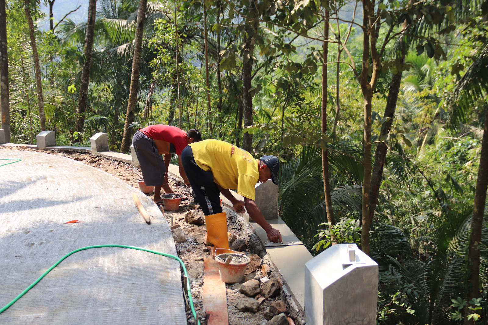 Kang Har mengerjakan pengacian pada bagian pembatas rabat beton dalam pembangunan jalan TMMD Reguler ke-129 Kodim 0704/Banjarnegara di Dusun Kunir, Desa Gumelem Kulon, Sabtu (08/08/2026).