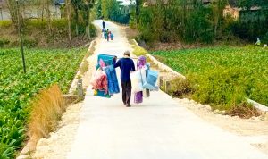 Pedagang keliling melintas di jalan beton hasil pembangunan program TMMD ke-129 di Dusun Mundu, Desa Kesongo, Kecamatan Kedungadem, Kabupaten Bojonegoro, Senin (10/8/2026). Foto: Deni Flamboyan/Sumber TMMD Bojonegoro