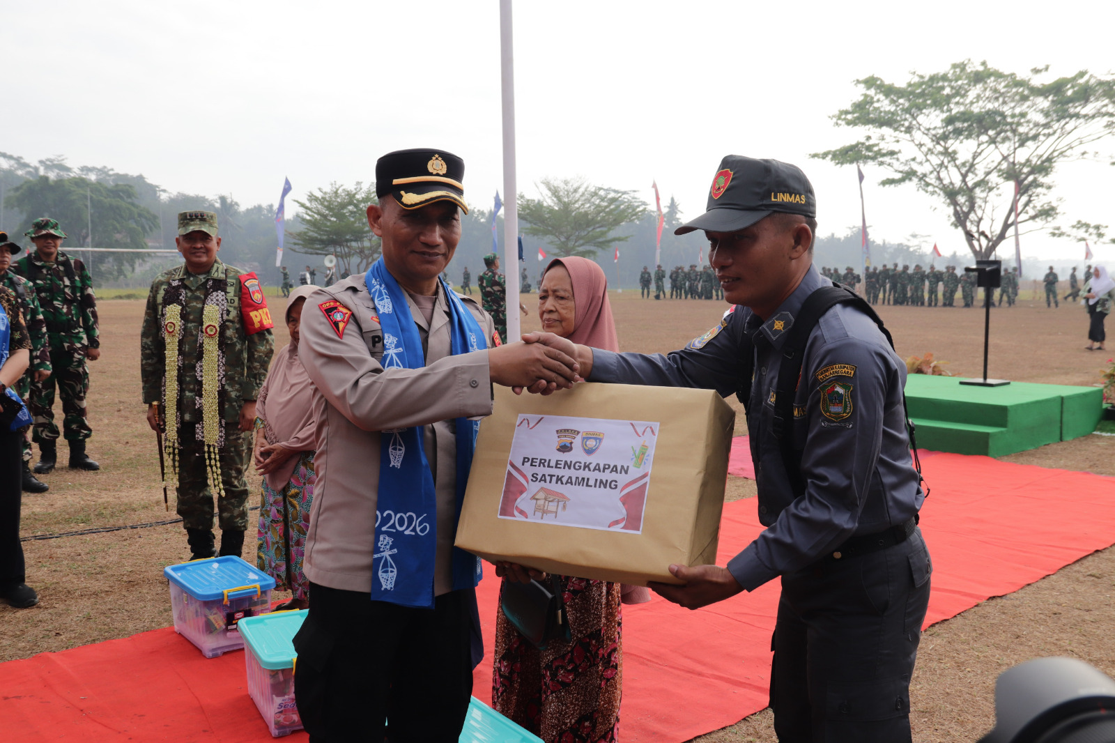 Keterangan Foto: Kabag Ops Polres Banjarnegara Kompol Priyo Jatmiko, S.Sos., S.H., menyerahkan bantuan perlengkapan Pos Kamling kepada masyarakat dalam rangkaian penutupan TMMD Reguler ke-129 Tahun Anggaran 2026 di Desa Gumelem Kulon, Kecamatan Susukan, Kabupaten Banjarnegara, Kamis (13/8/2026). Foto: Pendim Banjarnegara.