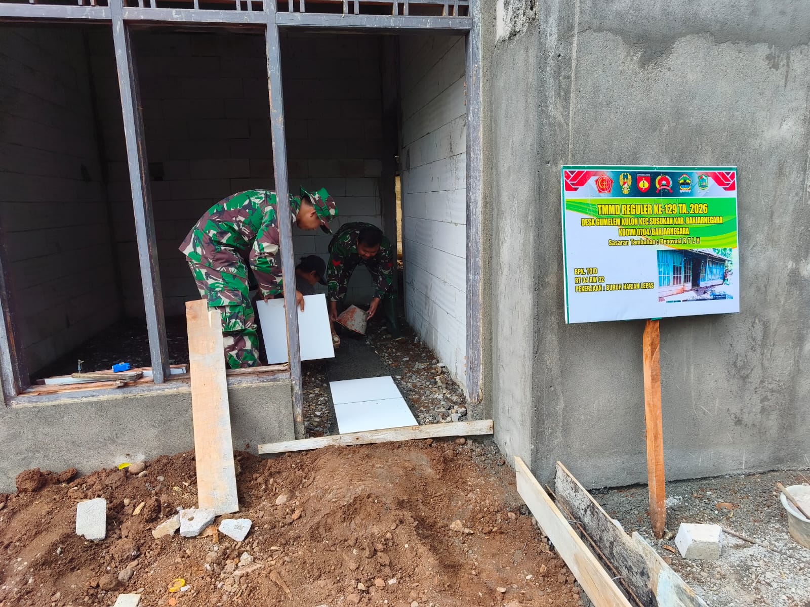 Hunian Lebih Nyaman: Anggota Satgas TMMD Reguler ke-129 Kodim 0704/Banjarnegara bersama warga memasang keramik lantai rumah Pak Toid dalam program RTLH di Desa Gumelem Kulon, Kecamatan Susukan, Jumat (7/8/2026). Pemasangan keramik menjadi salah satu tahapan akhir menuju rumah yang lebih layak huni.