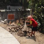 Mbah Sariem ikut mengumpulkan batu untuk mendukung pembangunan rabat beton TMMD Reguler ke-129 di Dusun Kunir, Desa Gumelem Kulon, Kecamatan Susukan, Banjarnegara.