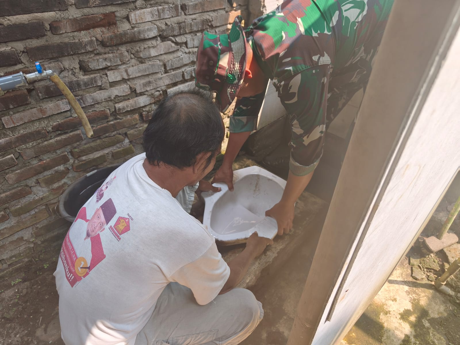 Keterangan Foto: Anggota Satgas TMMD bersama warga mengerjakan pemasangan keramik pada rumah Pak Toid yang menjadi sasaran RTLH TMMD Reguler ke-129 Kodim 0704/Banjarnegara di Desa Gumelem Kulon.