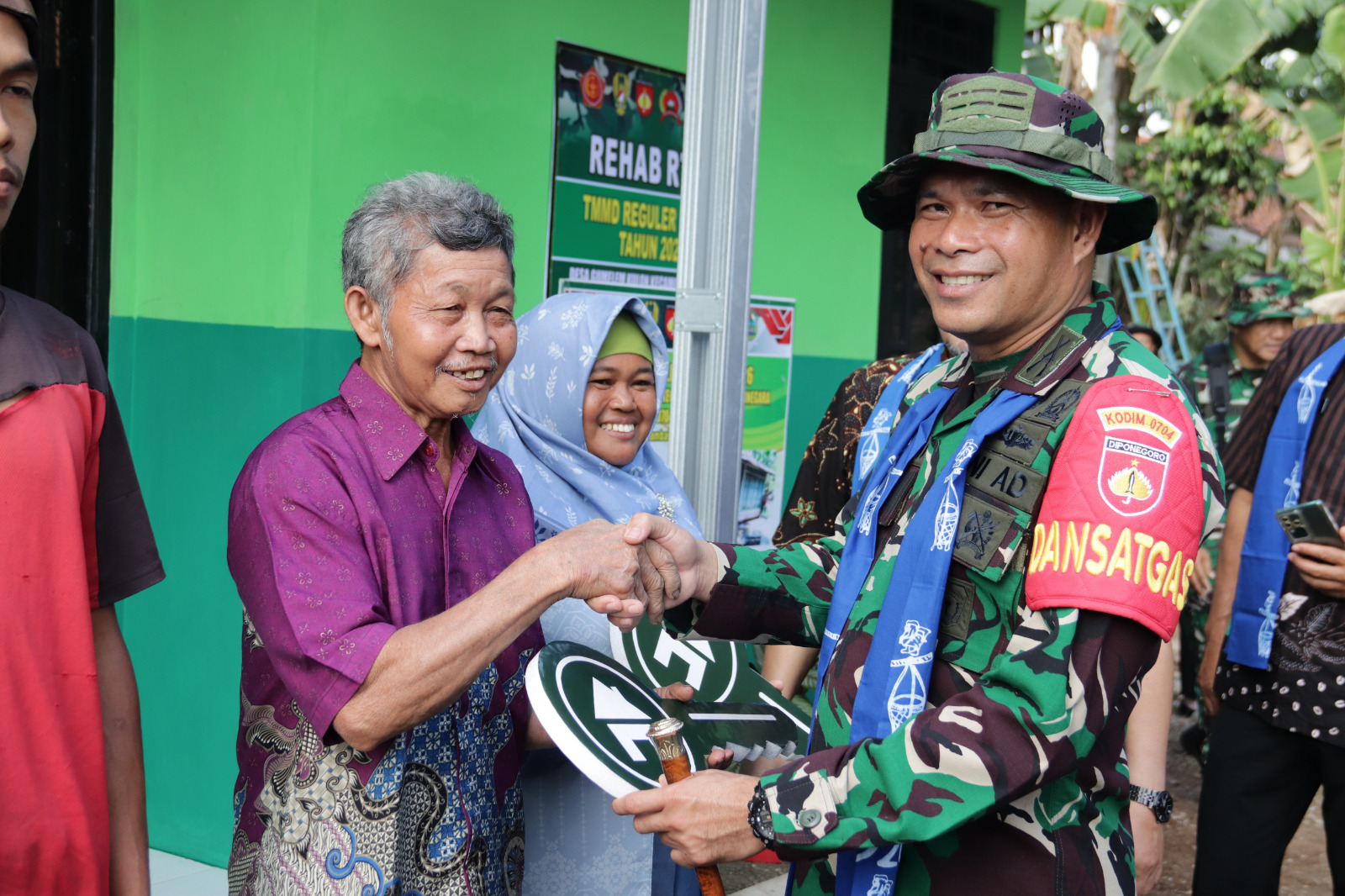 Keterangan Foto: Dandim 0704/Banjarnegara Letkol Inf Nodelismen Hulu, S.Pd., bersama Sekda Banjarnegara Hendro Cahyono, S.E., M.Si., menyerahkan kunci secara simbolis kepada penerima program RTLH dalam rangkaian penutupan TMMD Reguler ke-129 Tahun Anggaran 2026 di Desa Gumelem Kulon, Kecamatan Susukan, Kabupaten Banjarnegara, Kamis (13/8/2026). Foto: Pendim Banjarnegara.